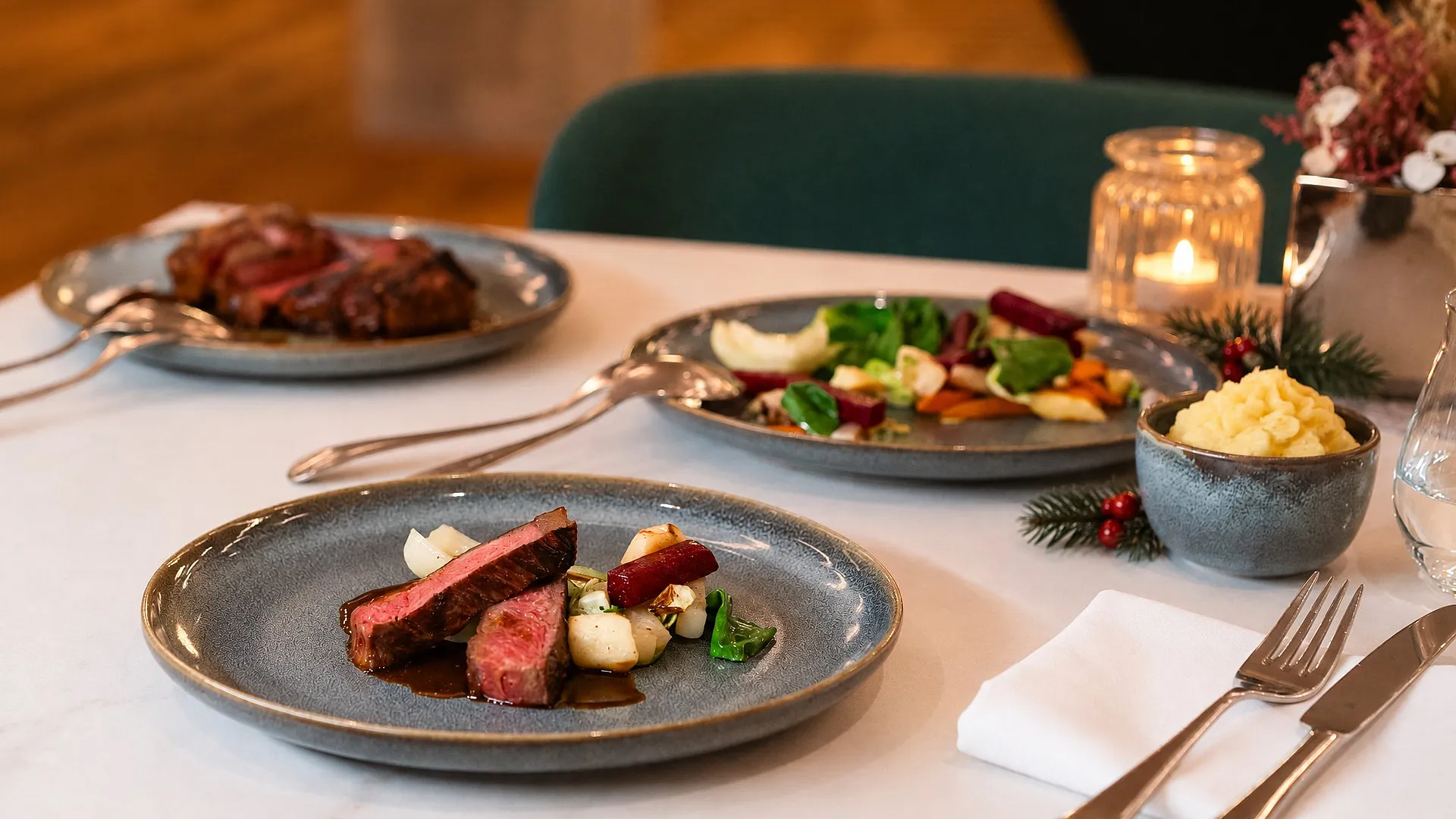 Gedeckter Tisch mit Weihnachtsmenü und Kerze im Restaurant der Ehemaligen Sparkasse