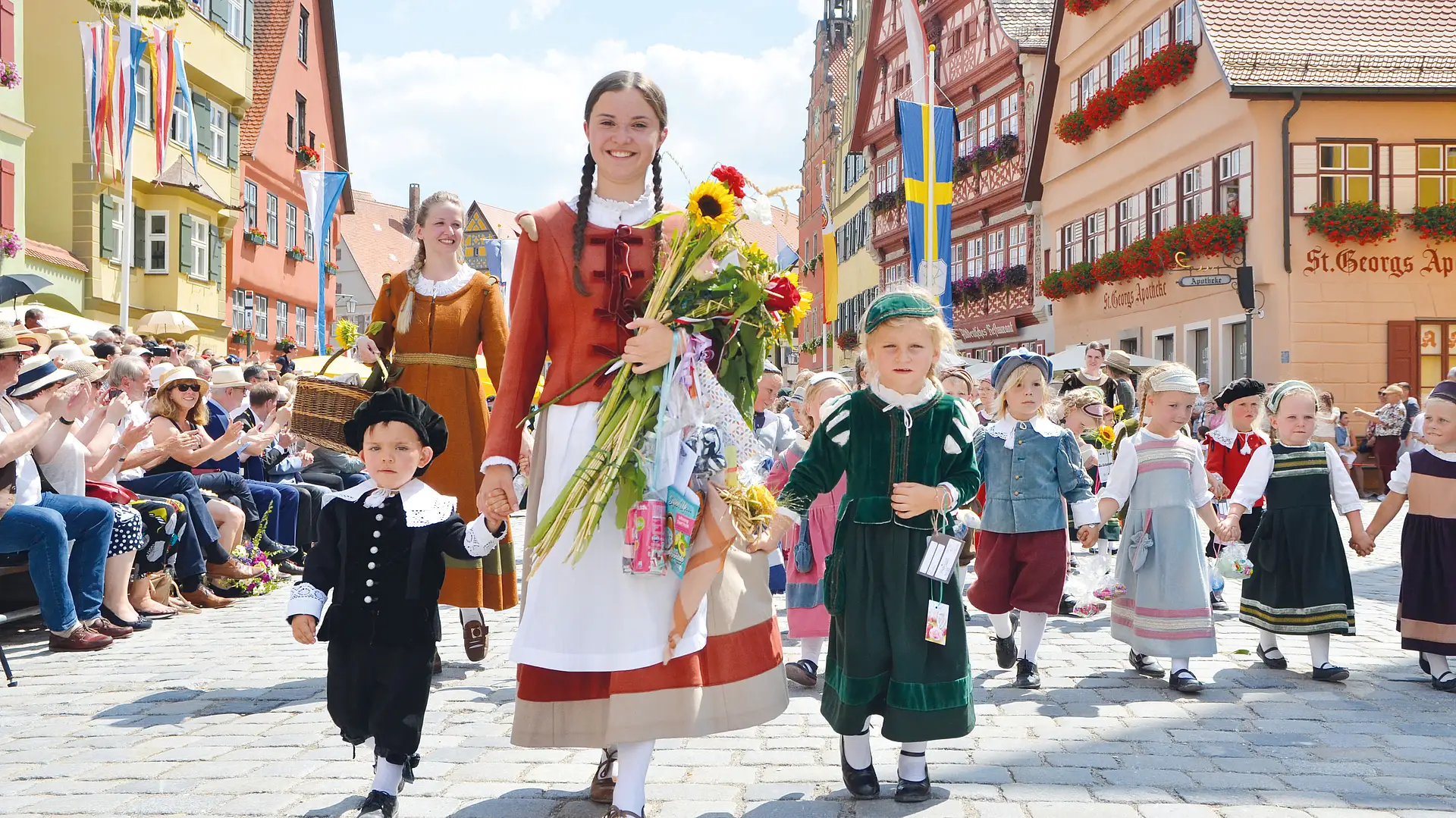Die Kinderlore mit Blumenstrauß führt bei der Kinderzeche eine Kinderschar in historischen Gewändern durch die Altstadt