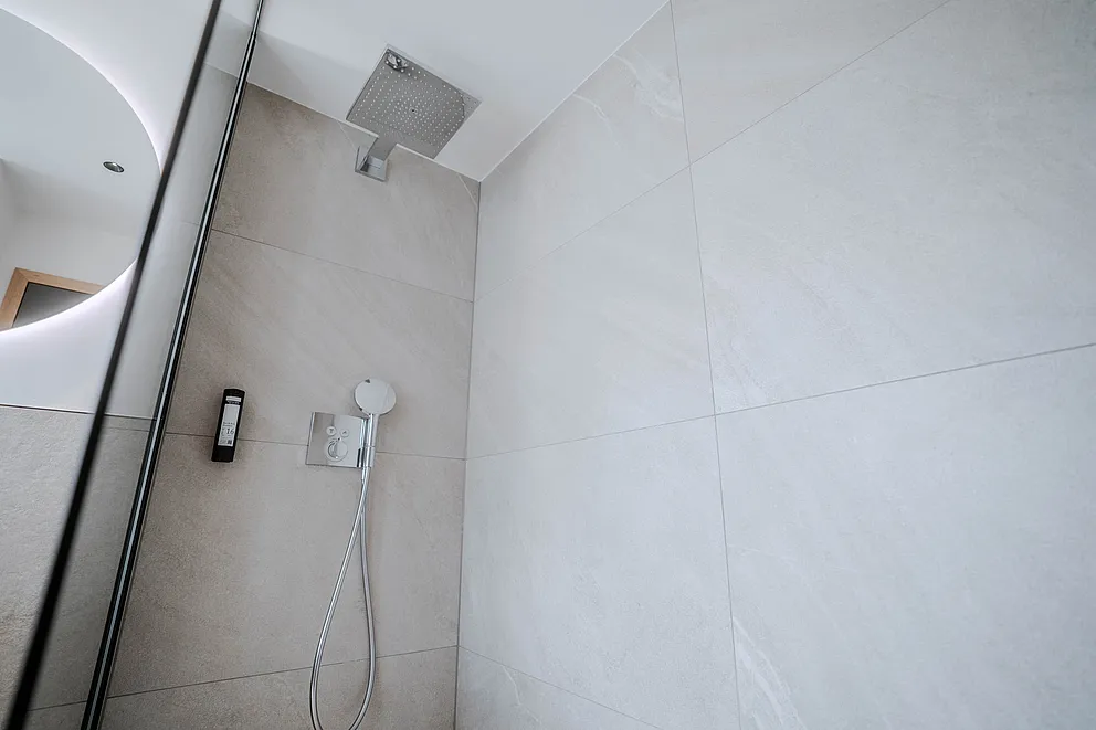 Dusche mit Regenbrause, Handbrause und Glasabtrennung im Bad der Suite im Haus Ehemalige Sparkasse