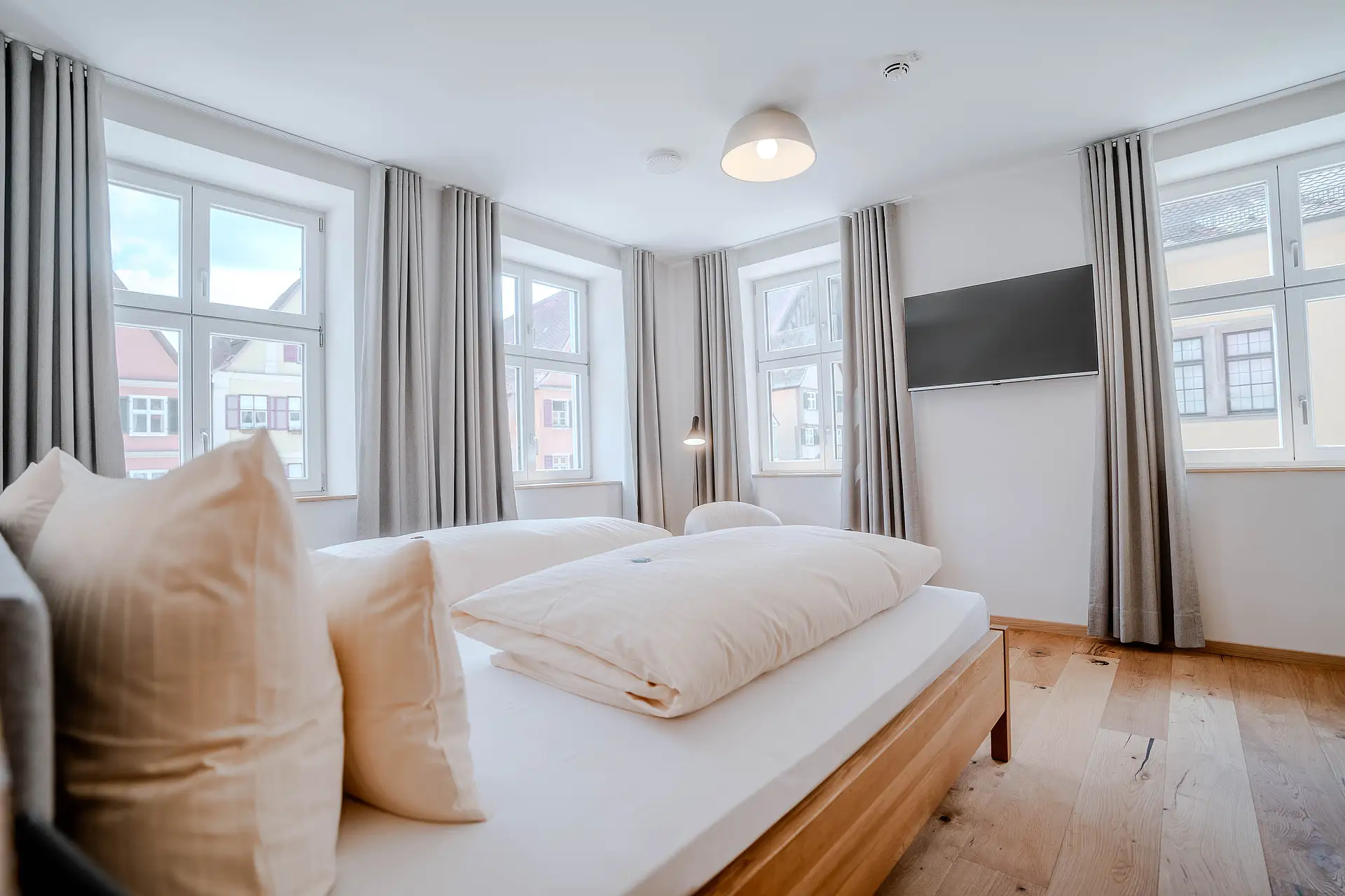 Superior-Zimmer im Haus Ehemalige Sparkasse mit Doppelbett, Wand-TV und mehreren Fenstern zur Altstadt