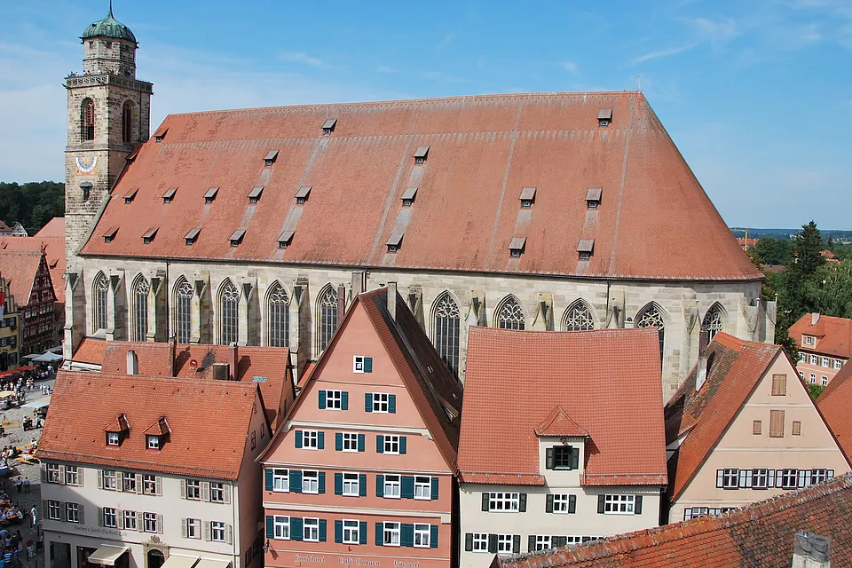Erhöhter Blick auf das Münster St. Georg mit großem Ziegeldach und Turm, umgeben von Giebelhäusern der Altstadt